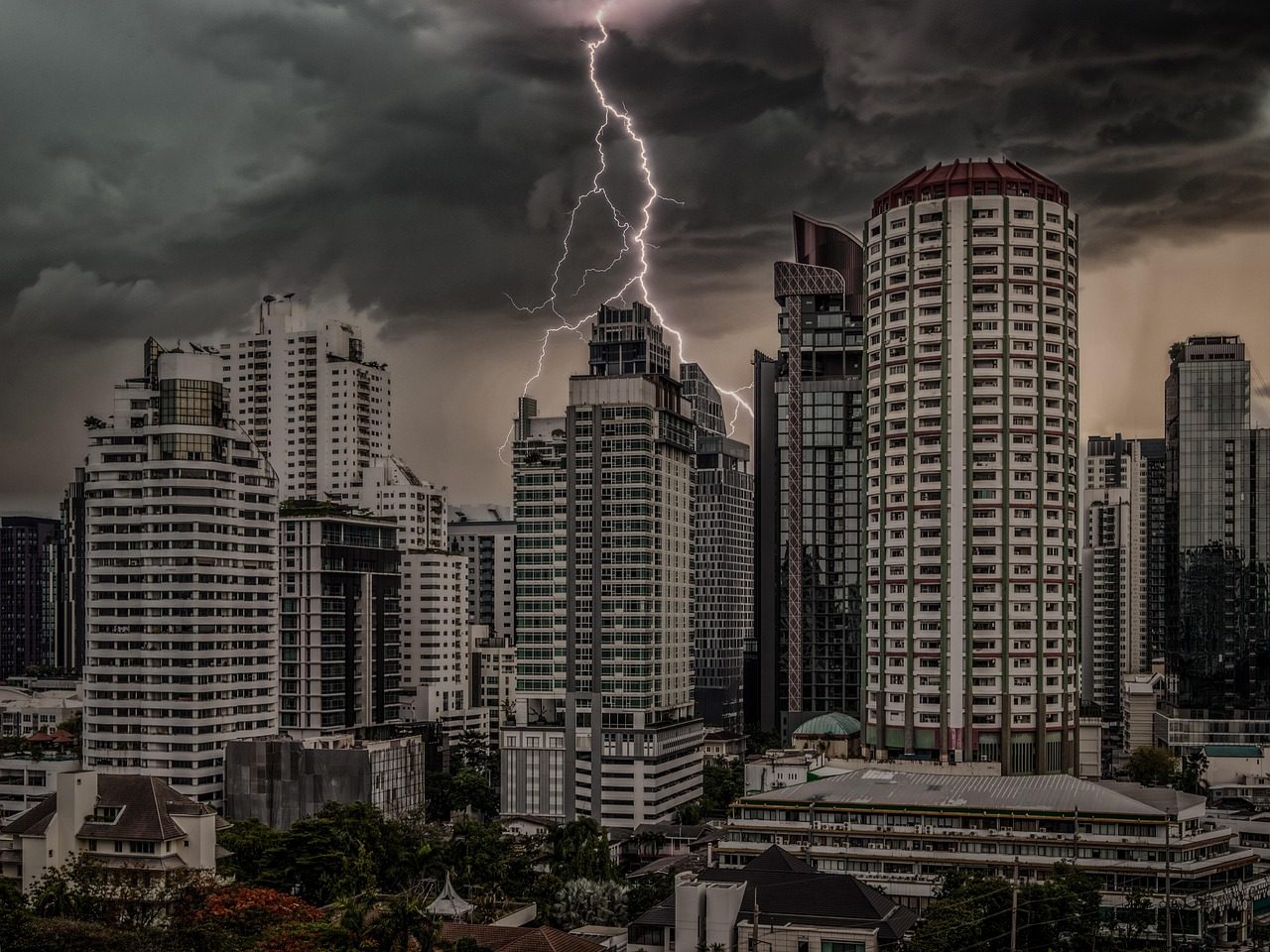 Raio atingindo o céu sobre prédios de uma cidade